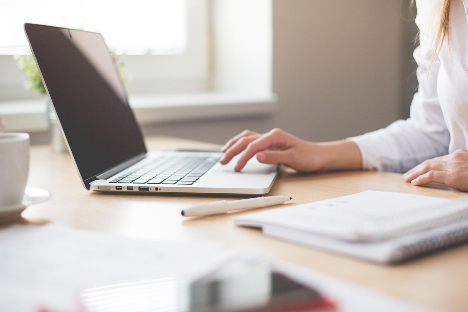 Executive assistant working at a laptop in a bright, warm office