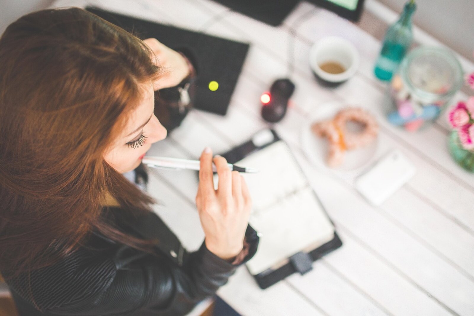 Team member planning work in a notebook at a warm, light-filled desk